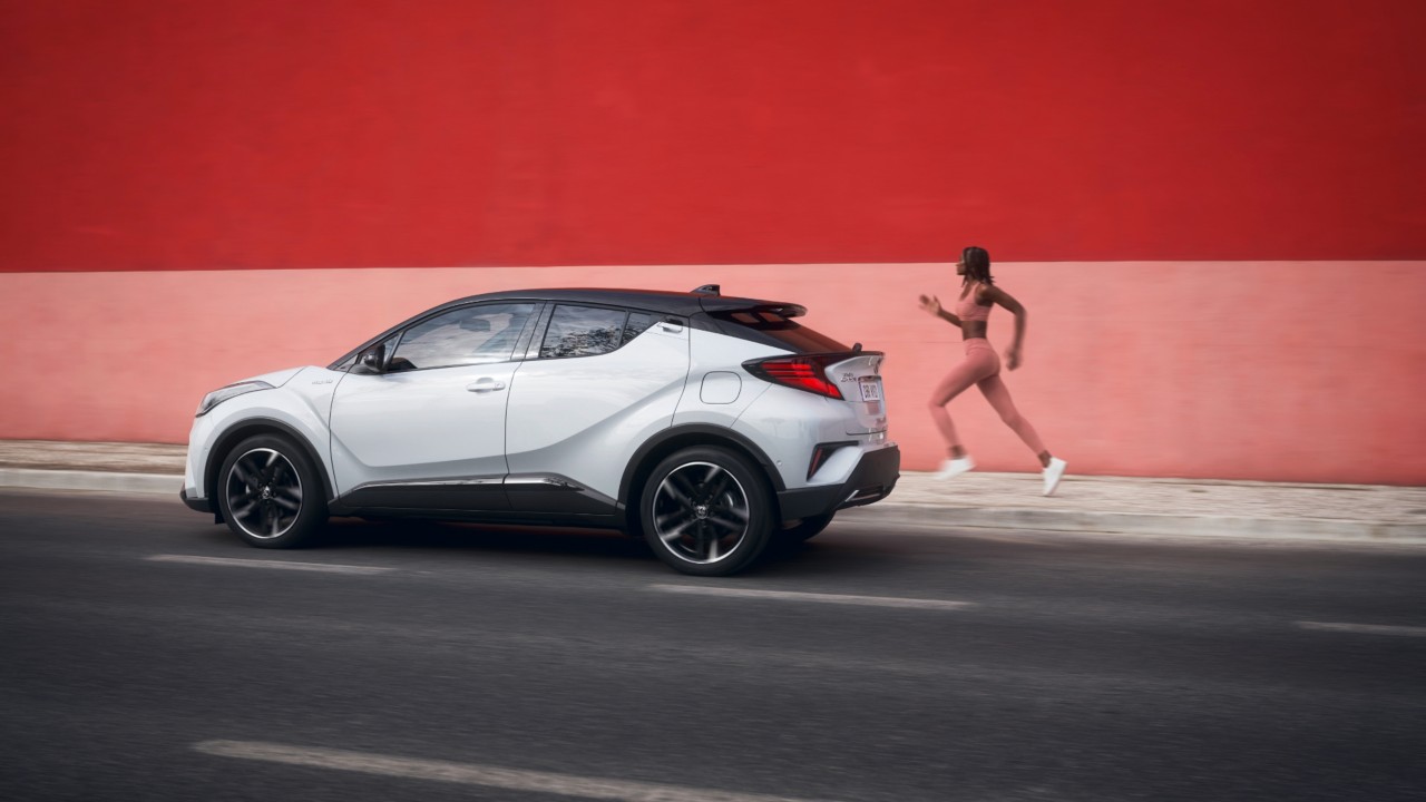 person running past a Toyota C-HR outside