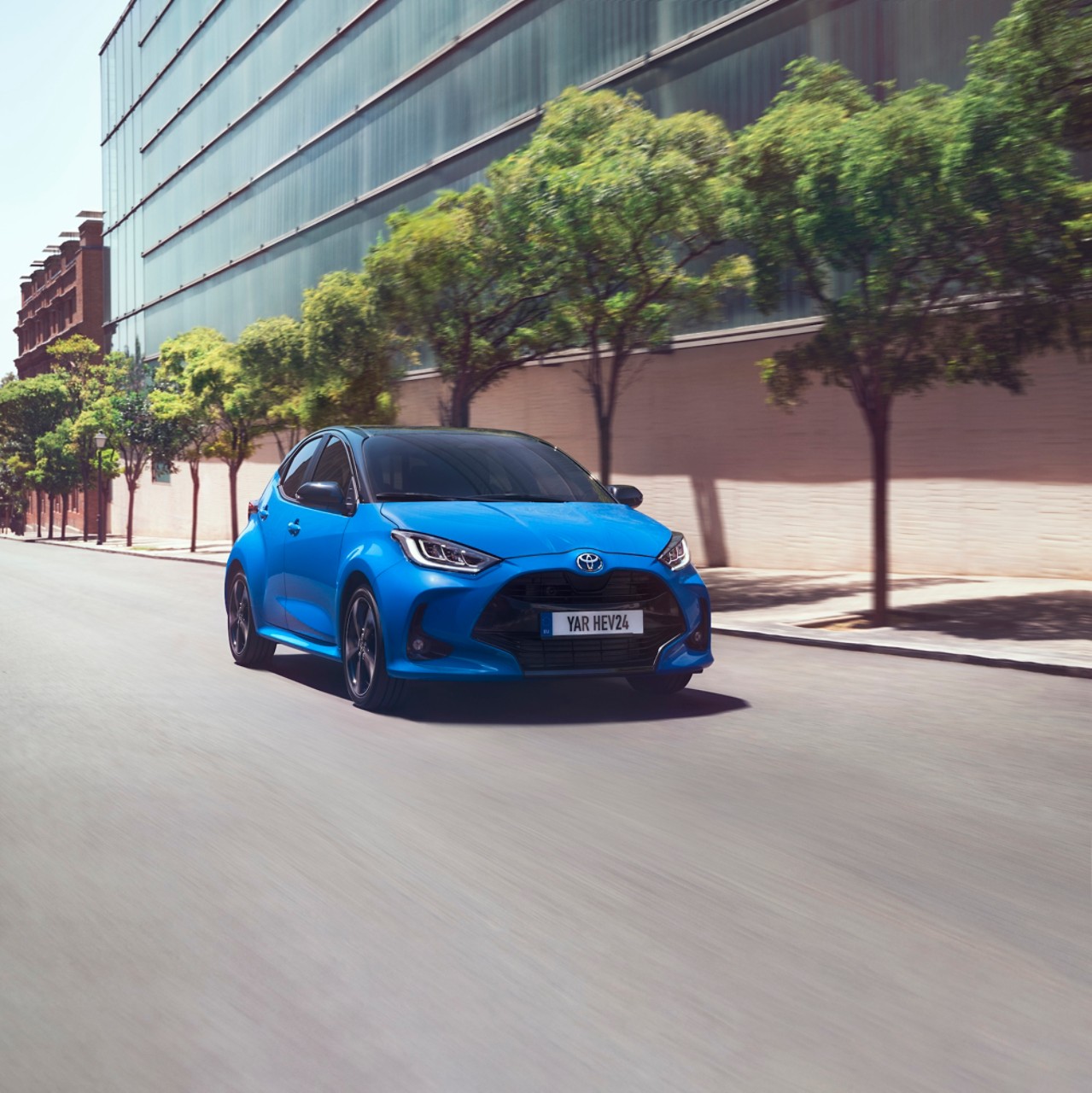 Toyota Yaris Hybrid blue driving on city road